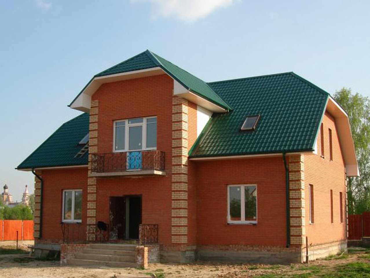 Дом из красного кирпича с зеленой крышей